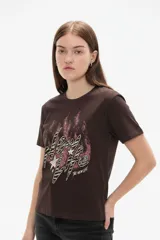 Remera de manga corta y cuello redondo, confeccionada en algodón de color marrón, con diseño estampado en el frente con efecto desgastado.