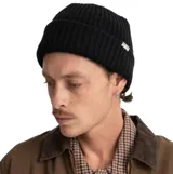 Gorro tipo beanie de punto acanalado en color negro, con diseño de doblez y etiqueta pequeña de la marca en el lateral.