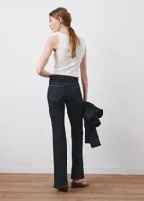 Jeans de denim azul oscuro de tiro medio y corte acampanado, con costuras contrastantes y bolsillos clásicos.