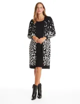 Vestido midi de tejido de punto con diseño integrado que simula un conjunto de vestido liso y cárdigan estampado. Presenta escote redondo, manga larga y un estampado de manchas tipo animal print en los laterales del cárdigan.