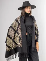 Pashmina color bordó con bordados florales en hilo dorado y bronce, terminada con flecos en los extremos.