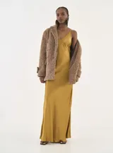 Vestido largo de satén color dorado, con escote en V, breteles finos y corte al bies con caída fluida.