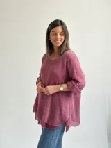 Sweater Ginebra de punto color magenta, con escote redondo, mangas largas con presilla y botón para ajustar, y diseño holgado con bajo asimétrico.