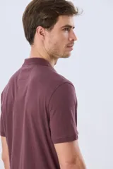 Remera polo de manga corta en color azul melange, con cuello camisero, cierre frontal de dos botones y pequeño bordado en el pecho.