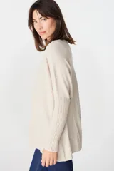 Sweater crudo de punto con cuello alto y mangas largas con puños ajustados.