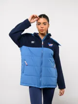 Parka de abrigo Umbro del Club Nacional de Football, con diseño bicolor que combina tejido polar blanco en la parte superior y tejido acolchado azul marino en la parte inferior. Cuenta con cierre frontal completo, cuello alto y bolsillos laterales.