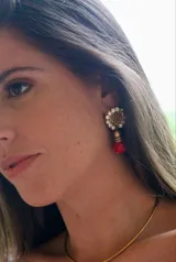 Aros colgantes con base circular dorada con strass y dije de cuentas rojas.