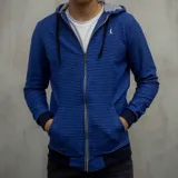 Campera con capucha azul a rayas horizontales negras, con cierre frontal y bolsillos laterales.