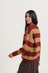 Buzo de tejido de punto con diseño de rayas horizontales en tonos bordó y beige, de cuello redondo y mangas largas.