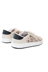 Championes urbanos con diseño de paneles combinados en cuero liso color crema y piel con estampado animal print. Presentan detalle de talón en cuero negro, cordones al tono y suela de goma blanca.