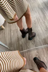 Bota de cuero color chocolate, con caña media, cierre lateral y tachas decorativas en la parte trasera.