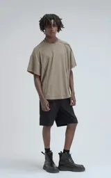 Remera de manga corta y cuello redondo, color verde militar, confeccionada en algodón premium con textura de tejido a rombos. Presenta un calce regular con recortes deshilachados en los hombros.