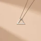 Collar de plata 925 con cadena fina de eslabones y dije geométrico en forma de triángulo calado.