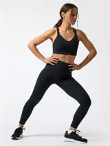 Top deportivo negro de soporte alto con tirantes ajustables, escote en V y tecnología Aloe Vera para mayor suavidad.