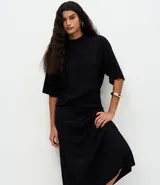 Pollera midi de corte evasé confeccionada en punto, con cintura elástica y caída fluida.