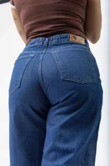 Pantalón de jean azul oscuro, tiro alto, de corte ancho (wide leg) y largo.