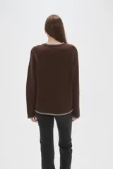 Cardigan de viscosa color marrón, con cuello en V, cierre frontal con botones y detalle de costura decorativa en contraste a lo largo de los bordes.