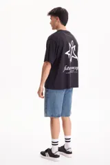 Remera de algodón negra, de manga corta y corte semi boxy, con estampa en la espalda que presenta una estrella con efecto de pintura goteando y la inscripción "future concept defining tomorrows streetstyle // culture // art".