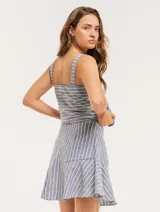 Musculosa de lino a rayas verticales azules y blancas, con breteles anchos y ruedo con flecos.