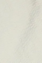 Pantalón de algodón color crema con textura seersucker, corte recto, bolsillos laterales y traseros, cierre con botón y cremallera.