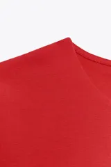 Top blanco de manga sisa con cuello redondo y corte ajustado al cuerpo.