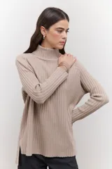 Polera de tejido de punto acanalado en color negro, con cuello alto y diseño de corte recto con largo asimétrico, más corto adelante y más largo atrás.