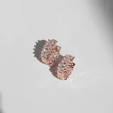 Par de aros tipo argolla oro rosa con cristales blancos en la superficie exterior e interior.