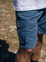 Bermuda cargo color azul de corte regular, con bolsillos laterales con solapa y etiqueta de la marca Brixton.