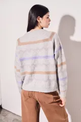 Sweater gris melange de punto con cuello redondo y mangas largas. Presenta rayas horizontales en tonos marrón y lila.