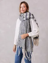 Bufandón de tejido soft con diseño de rayas horizontales en tonos gris y blanco, con terminación de flecos largos en los extremos.