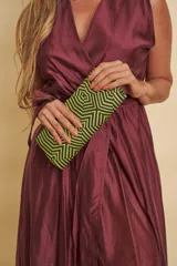 Clutch rígido de mano con diseño geométrico en tonos verde y negro.