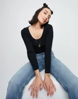 Collar largo dorado con cadena de eslabones rectangulares y cierre de mosquetón entrelazado.