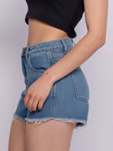 Short de jean celeste con terminación desflecada, cinco bolsillos, botón y cierre metálicos.