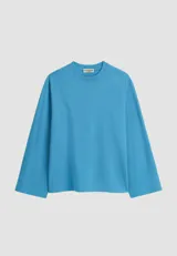 Remera oversize de manga larga y ancha, color celeste, confeccionada en algodón con cuello redondo.