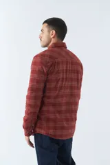Sobrecamisa de algodón a cuadros color ladrillo, con interior de corderito, cierre con botones, bolsillos tipo cartera y logo en goma. El modelo usa talle M.