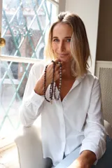 Camisa de fibrana blanca con cuello clásico, cierre frontal de botones y mangas largas con puños abotonados. Presenta un diseño minimalista y versátil.