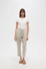 Pantalón tipo babucha de corte recto y tiro medio, con cintura elástica y cordón ajustable con borlas decorativas. Presenta un diseño de rayas verticales en tonos neutros.