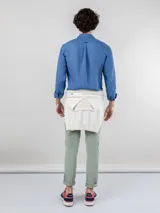 Pantalón chino azul marino de corte slim fit, confeccionado en gabardina con 77% algodón, 20% de algodón reciclado y 3% elastano. Presenta bolsillos delanteros y traseros. Tiene un lavado final con enzima ácida que le da un aspecto desgastado.