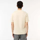 Camiseta de manga corta en color beige, con cuello redondo y diseño de ajuste cómodo y holgado.