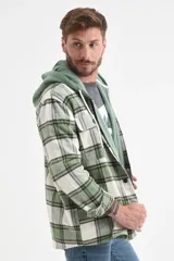 Camisa de franela a cuadros en tonos verde, blanco y marrón, con botones frontales y bolsillos en el pecho.