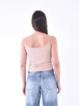 Musculosa blanca con tirantes finos en verde y estampado de palmeras en el pecho.