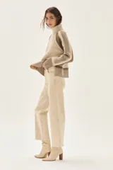 Jean de tiro alto y pierna ancha, color beige claro, con terminación deshilachada en el ruedo.