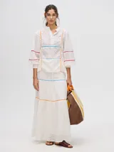 Falda larga confeccionada en broderie de algodón, con diseño de volados escalonados y detalles de galones con transparencias. Presenta una pretina elástica con cordones ajustables para un calce cómodo.