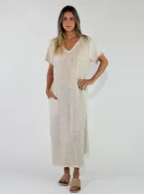 Vestido largo azul de corte recto, con escote en V, mangas cortas con flecos y bolsillos laterales.