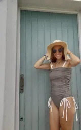 Traje de baño enterizo color visón con diseño fruncido en el frente y tirantes finos en color natural.