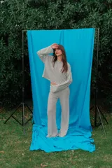 Conjunto de dos piezas de rib blanco con rayas horizontales negras, compuesto por un buzo oversize de mangas largas acampanadas y un pantalón de corte recto y holgado.