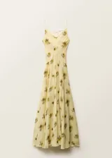 Vestido largo de tirantes finos con cuello de pico, confeccionado en viscosa con estampado floral difuminado en tonos amarillos y marrones. Presenta un diseño recto con detalle de cadena metálica a la altura de la cadera y cierre de lazo en la espalda.