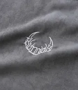 Remera oversized masculina de media malla con toque gamuza, color gris oscuro con efecto lavado. Presenta un bordado blanco en forma de media luna en el pecho y un estampado lettering en la parte delantera y trasera.