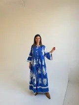 Vestido largo color azul con estampado ornamental en color blanco, escote en V con botones frontales y mangas tres cuartos con volados.