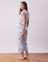 Conjunto de pijama marca René Rofé, compuesto por remera de mangas cortas con escote en V abotonado y pantalón capri con cintura elastizada. Diseño estampado con flores azules sobre fondo blanco.